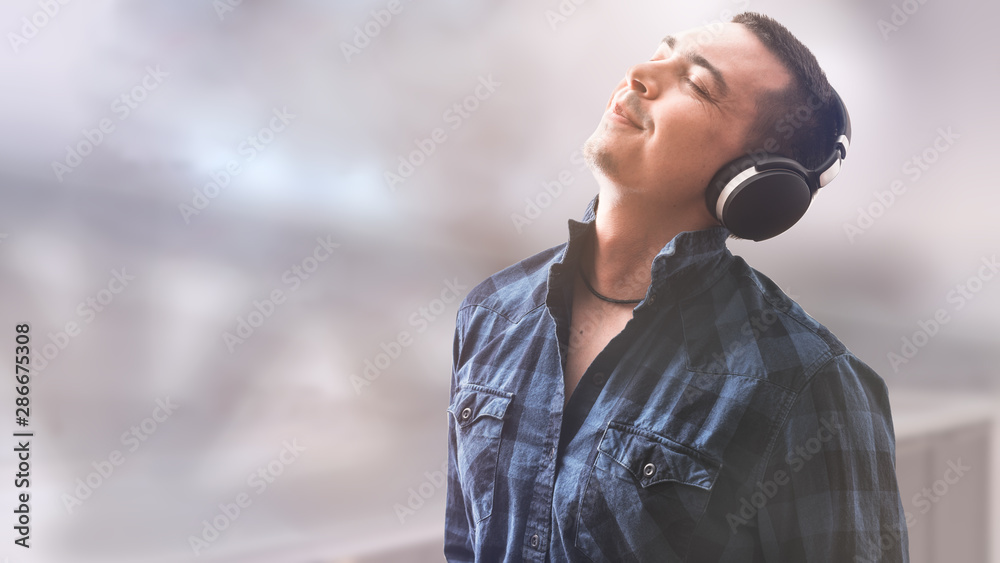 Man with headphones on pastel background. Black headphones. Leisure concept. Technology background. Digital gadget. Smart person.