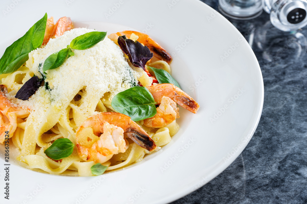 Top view pasta with seafood, shrimp, basil, and parmesan on marble table. Spaghetti in a white bowl. Traditional Italian cuisine. Copy space. Selective focus. Food photography Top view pasta with seafood, shrimp, basil, and parmesan on marble table. Spaghetti in a white bowl. Traditional Italian cuisine. Copy space. Selective focus. Food photography