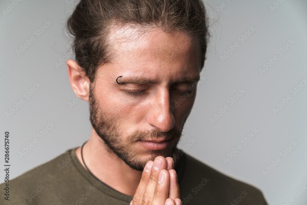 Concentrated young man standing isolated over gray Concentrated young man standing isolated over gray
