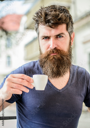 Enjoy hot drink. Hipster drinking fresh brewed coffee. Bearded guy consume caffeine. Espresso arabica only. Coffee break concept. Guy relaxing espresso. Man with beard and mustache and espresso cup
