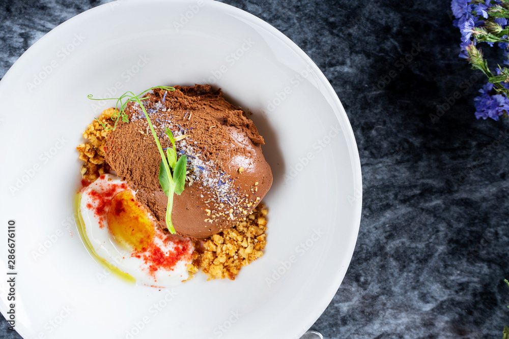 Selective focus on tasty chocolate ice cream with sea salt and microgreen. Restaurant style modern ice cream. Sweet dessert after lunch. Flat lay marble table. Top view food photography Selective focus on tasty chocolate ice cream with sea salt and microgreen. Restaurant style modern ice cream. Sweet dessert after lunch. Flat lay marble table. Top view food photography