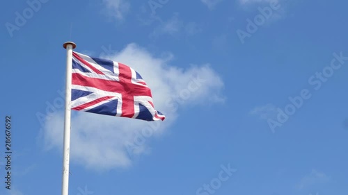 UK Union flag. Slow motion video footage of the UK flag also erroneously known as the Union Jack set against a bright blue sky.