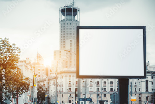 Mockup of a huge blank advert billboard in urban settings above the street  an empty vertical street banner template outdoors  an outdoor poster placeholder mock-up with a skyscraper in the background