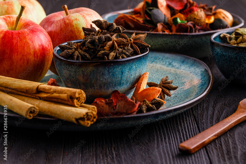 Apples, anis, cinnamon sticks and brown sugar on wooden background