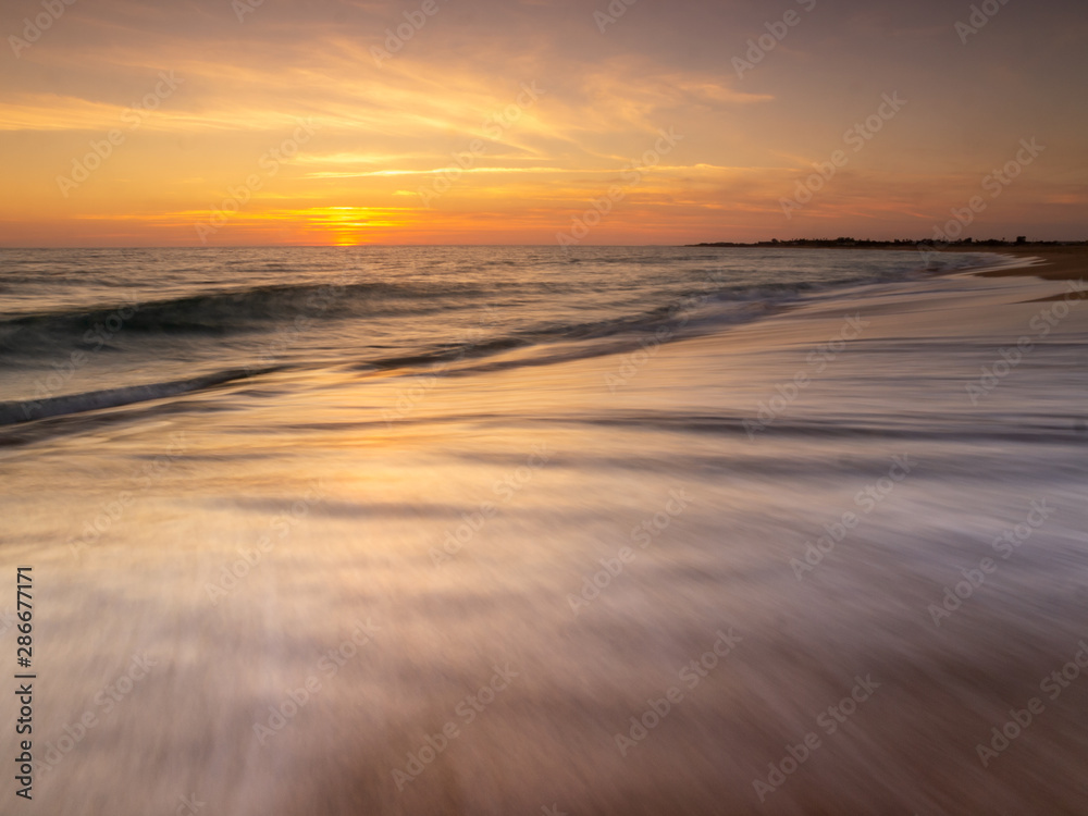 Sunset on the beach of Trafalgar Lighthouse, Caños de Meca, Andalusia, Spain.