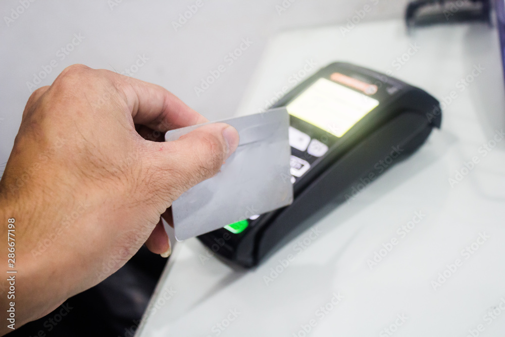 A portrait of EDC ( electronic Data Capture) machine , hand sweeping card on it. A portrait of EDC ( electronic Data Capture) machine , hand sweeping card on it.