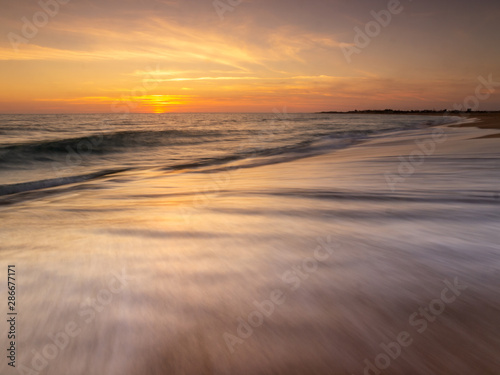 Sunset on the beach of Trafalgar Lighthouse, Caños de Meca, Andalusia, Spain. photo