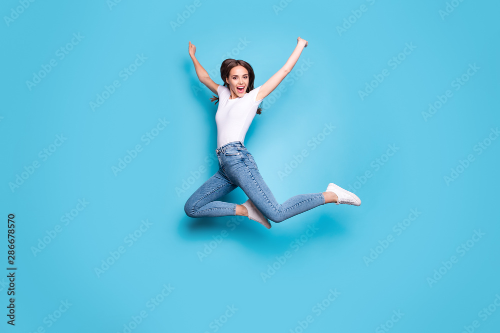 Full length photo of charming youth shouting wearing white t-shirt denim jeans sneakers isolated over blue background