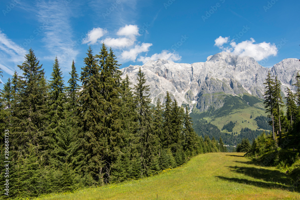 Hiking in Hochkonig (Austria) between the snowy and green mountains of the Austrian Alps