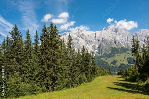 Hiking in Hochkonig (Austria) between the snowy and green mountains of the Austrian Alps
