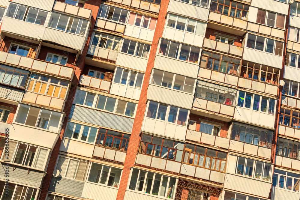 tilted photo with a large number of balconies on the wall of a multi-storey building
