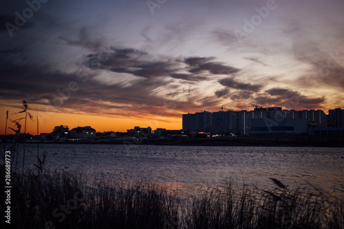 Sunset over the city and lake © Женя Максимов