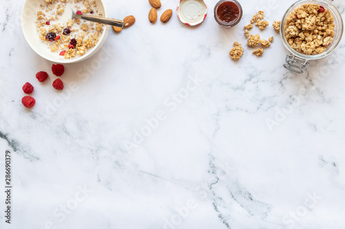 Breakfast with crunch with red fruits, almond milk and jam on a marble background. Top view. Copy space. Horizontal orientation.