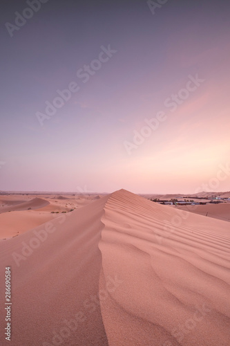 Sun set in dessert outside of Abu Dhabi with pink and red sky UAE 