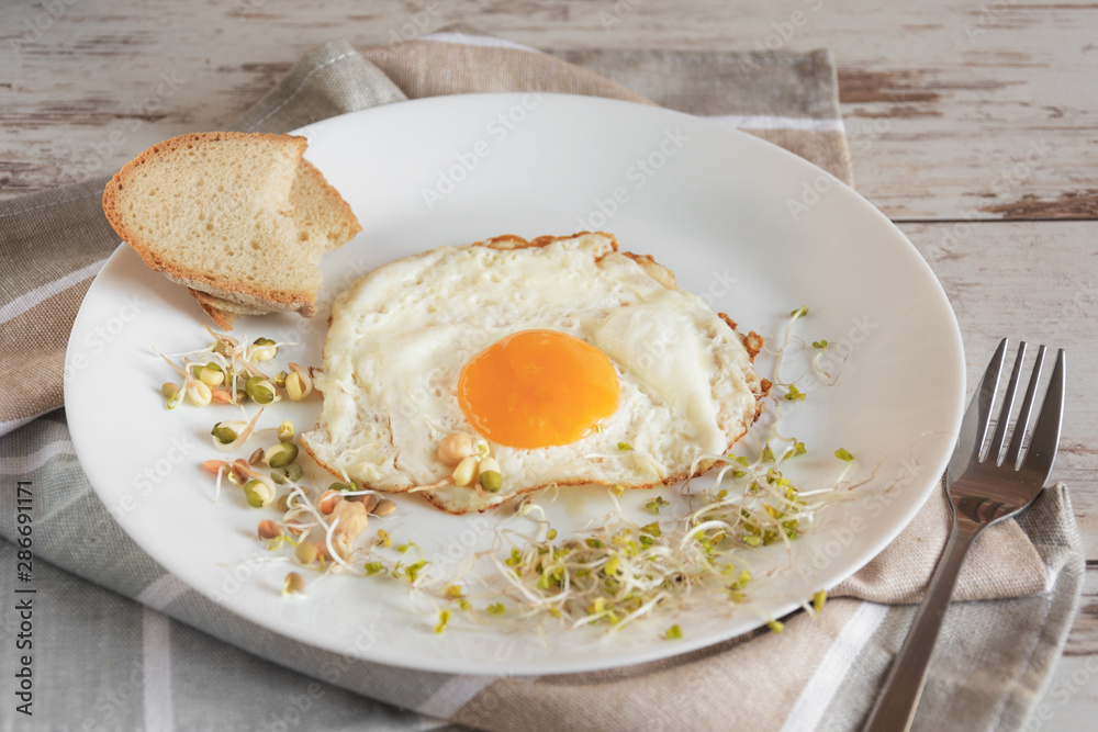 Healthy breakfast. Fried egg close up served with sprouted grain. Dieting concept. Healthy low calories food. Weight loss. Healthy breakfast. Fried egg close up served with sprouted grain. Dieting concept. Healthy low calories food. Weight loss.