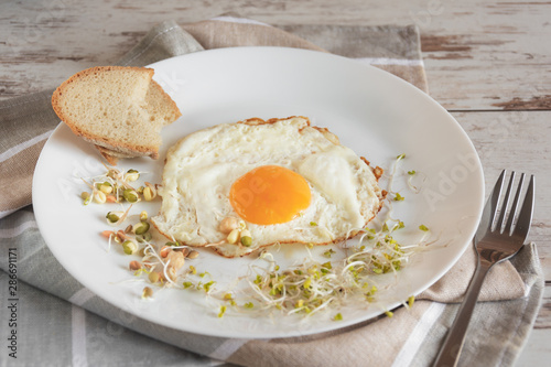 Healthy breakfast. Fried egg close up served with sprouted grain. Dieting concept. Healthy low calories food. Weight loss.