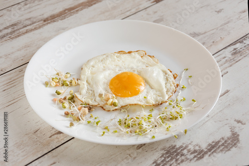 Healthy breakfast. Fried egg close up served with sprouted grain. Dieting concept. Healthy low calories food. Weight loss.