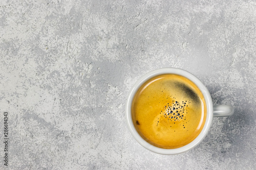 Black coffee in grey mug on concrete background. Top view, copy space.