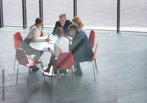 High angle view of colleagues planning while sitting during meeting at office