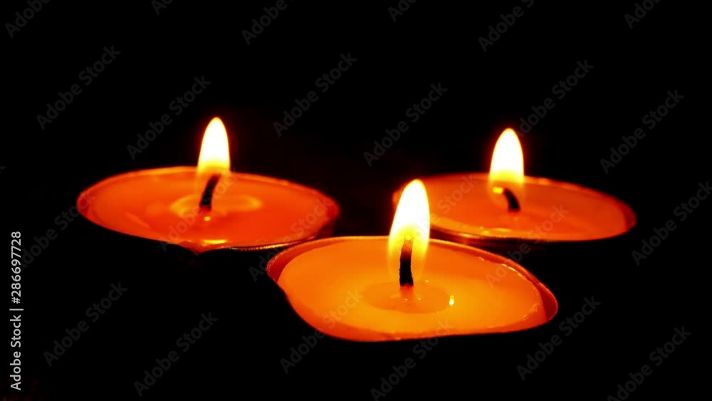 beautiful fire of a candle in a dark room a warm yellow light candle , fire of a candle  burning in the dark 
