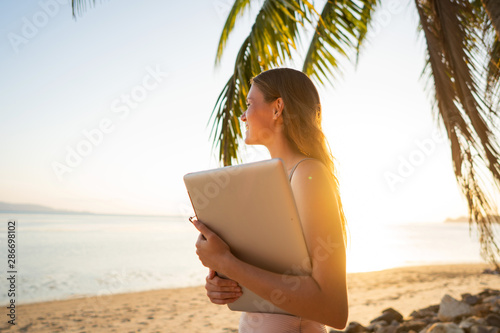 freelancer girl among tropical palm trees work on the island