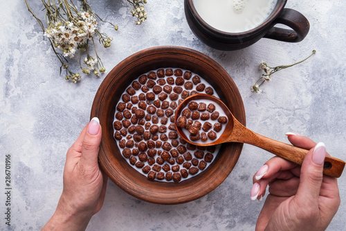 Carta da parati Hand holding spoon with chocolate cereal balls
