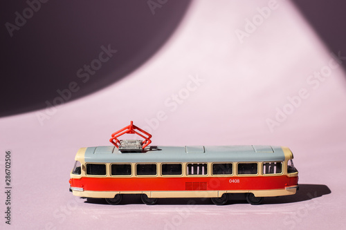 Model of a Russian tram on a pink background with sunlight. Russian transport. Toy model