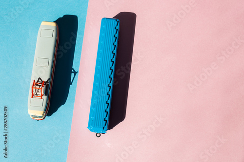 Models of a Russian metro car and tram on a pink background with sunlight. Russian transport. Toy models