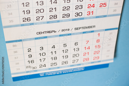Close-up calendar for the month of September 2019. Hello September. Hello, Autumn. Russian-English calendar on a blue background