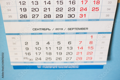 Close-up calendar for the month of September 2019. Hello September. Hello, Autumn. Russian-English calendar on a blue background