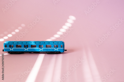 Model of a Russian metro car on a pink background with sunlight. Russian transport. Toy model