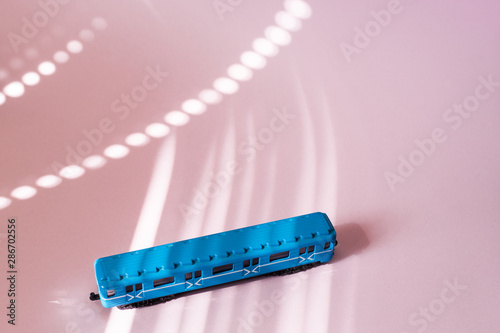 Model of a Russian metro car on a pink background with sunlight. Russian transport. Toy model