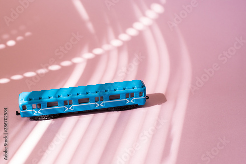 Model of a Russian metro car on a pink background with sunlight. Russian transport. Toy model