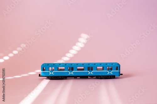 Model of a Russian metro car on a pink background with sunlight. Russian transport. Toy model
