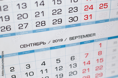 Close-up calendar for the month of September 2019. Hello September. Hello, Autumn. Russian-English calendar on a blue background