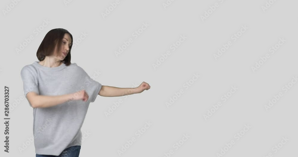 Happy young woman dancing in slow motion over white background Happy young woman dancing in slow motion over white background