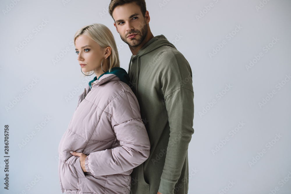stylish blonde girl and bearded man in autumn outfits isolated on grey stylish blonde girl and bearded man in autumn outfits isolated on grey