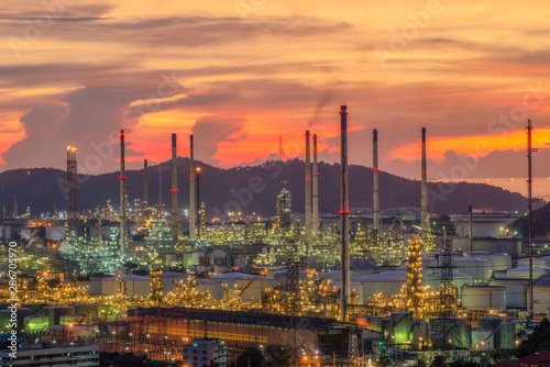 oil​ refinery​ and​ petrochemical​ plant​ industry, refinery​ factory, natural​ gas​ storage​ tank, silhouette​ petroleum​ industrial​ at​ yellow​ sunrise​ sky​ background​