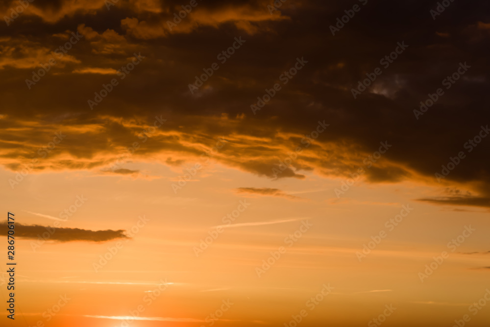 Stormy dramatic sky background with yellow red and orange clouds. Sunset skyline. Storm on the beach