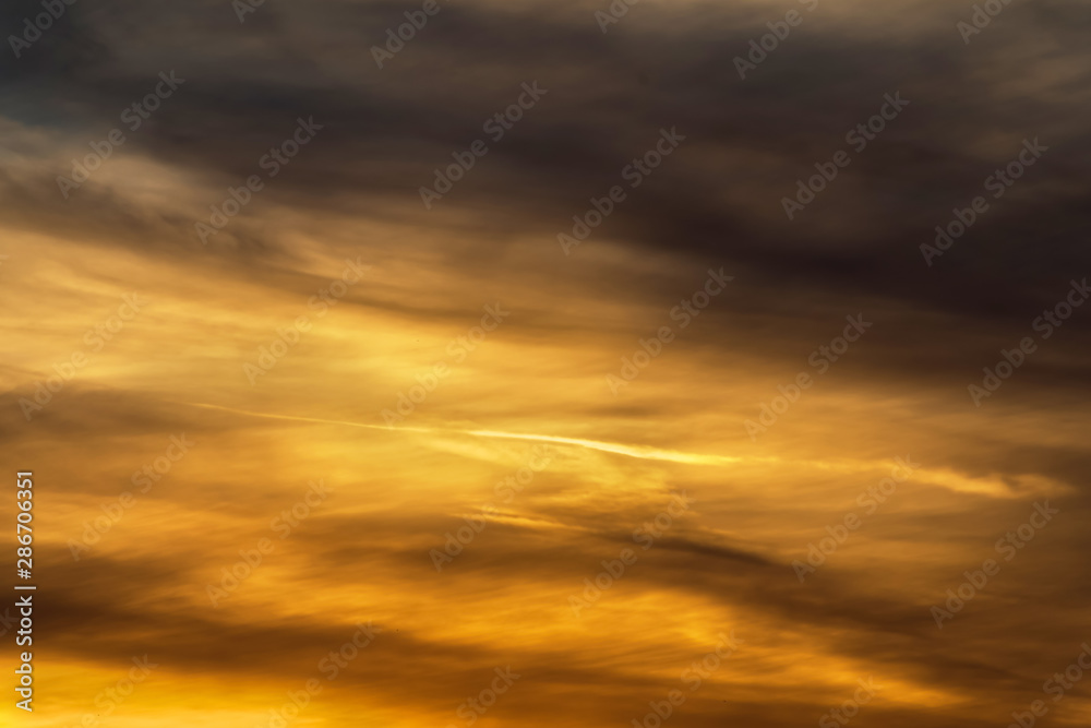 Stormy dramatic sky background with yellow red and orange clouds. Sunset skyline. Storm on the beach