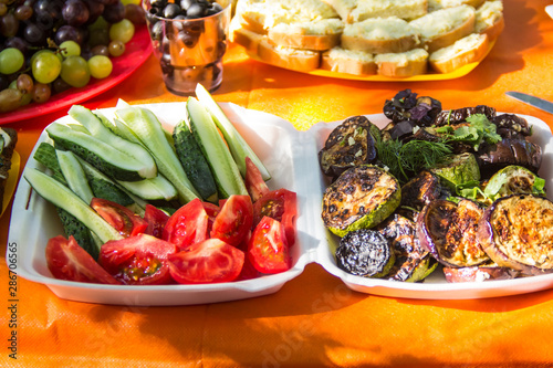 Grilled vegetables including eggplant, zucchini closeup and fresh tomato cucumber