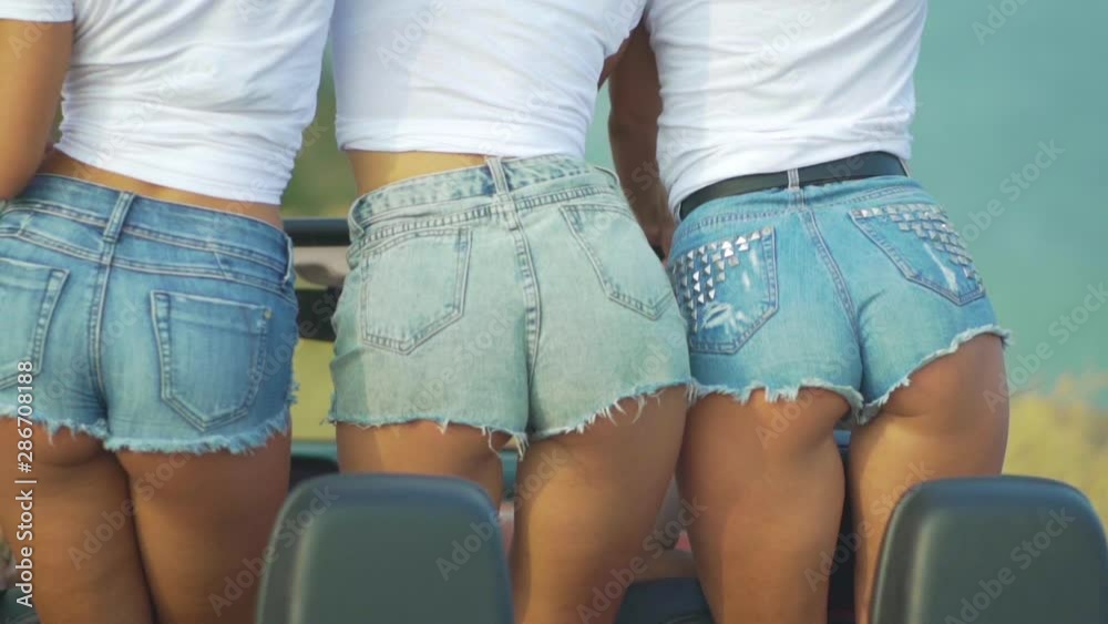 Three sexy girls in denim shorts move their buttocks. Dancing ass in jeans  . Stock Video | Adobe Stock