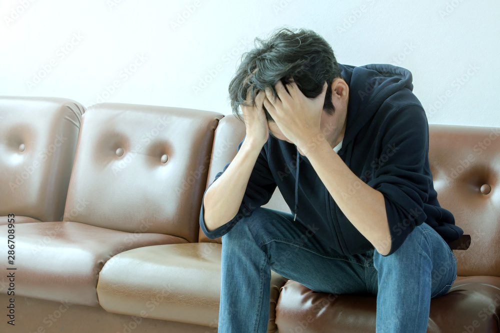 depressed man sitting on brown sofa and feeling sad depressed man sitting on brown sofa and feeling sad