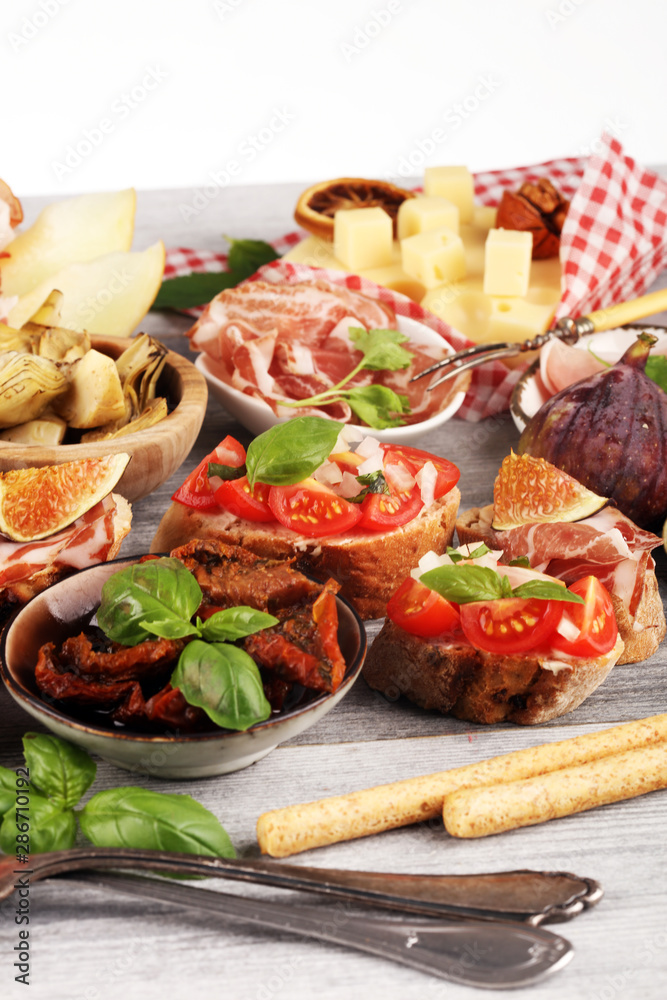 Italian antipasti wine snacks set. Cheese variety, Mediterranean olives, Prosciutto di Parma, tomatoes, artichokes