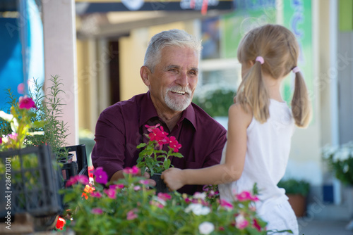 Girl and grandfather sold flowers at the green  market © nellas