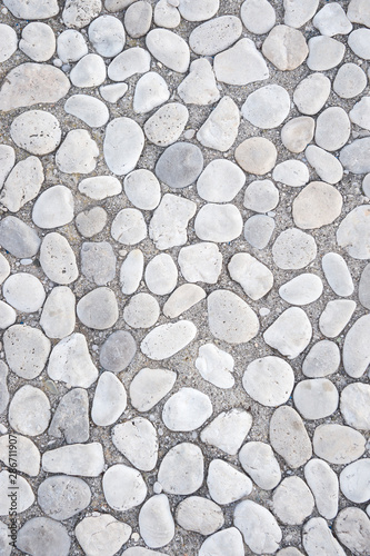 Full frame background of smooth white stones with rounded edges in gray mortar