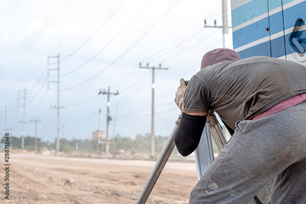 Surveyor engineer using equipment tacheometer or theodolite at road construction site.