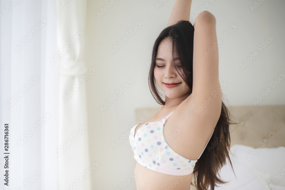 Beautiful young woman in cute underwear waking up in the morning and stretching in her bedroom Beautiful young woman in cute underwear waking up in the morning and stretching in her bedroom