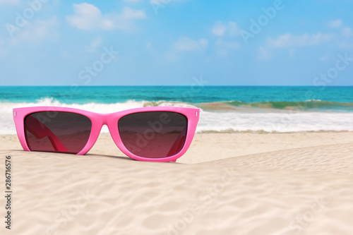 Summer Vacation Concept. Blue Skies with Modern Pink Sunglasses on an Ocean Deserted Coast. 3d Rendering
