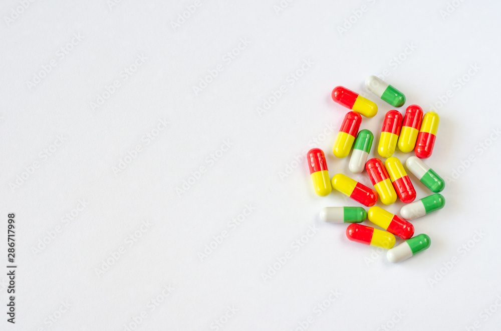 Heap of multi-colored capsules on a white background. Closeup of medicines. Copy space. Top view Heap of multi-colored capsules on a white background. Closeup of medicines. Copy space. Top view
